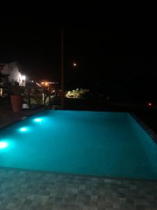 a swimming pool lit up at night at Casa de Campo Resort em Pardinho (Piscina c/ Borda Infinita) in Pardinho