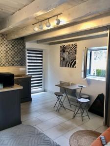 uma cozinha com mesa e cadeiras num quarto em La Tour charmant studio très bien situé em Tours-en-Savoie