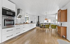 uma cozinha com armários brancos e uma mesa com cadeiras em Cozy Home In Ebeltoft With Kitchen em Ebeltoft