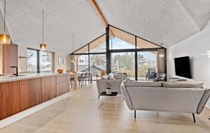 uma sala de estar com sofás e uma cozinha com janelas em Gorgeous Home In Millinge With House Sea View em Millinge