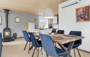 a dining room with a wooden table and blue chairs at 3 Bedroom Stunning Home In Fårvang in Fårvang