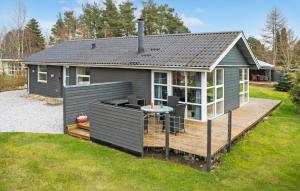a tiny house with a deck in a yard at 3 Bedroom Stunning Home In Fårvang in Fårvang +13 photos