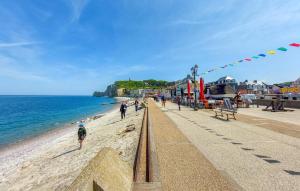 - une plage avec des personnes se promenant sur le sable et l'océan dans l'établissement Cozy Apartment In Sainte-adresse With Wifi, à Sainte-Adresse