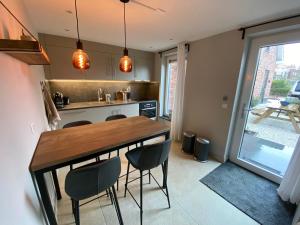 Una cocina con una mesa y sillas de madera. en Vakantiewoning Westkaap, en Westkapelle 24 fotos más