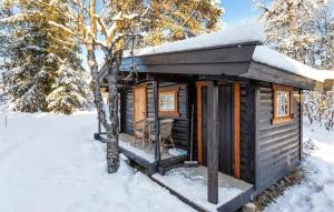 a log cabin in the snow with a chair at 3 Bedroom Amazing Home In Gol in Gol