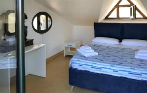 a bedroom with a blue bed and a mirror at Gorgeous Home In Giffoni Sei Casali With Outdoor Swimming Pool in Giffoni Sei Casali