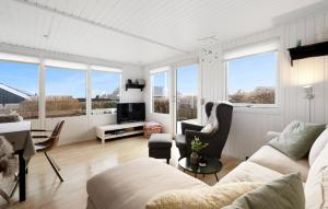 una sala de estar con muebles blancos y ventanas grandes. en 3 Bedroom Awesome Home In Juelsminde, en Sønderby