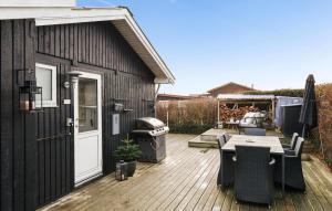 un patio con mesa y sillas en una terraza en 3 Bedroom Awesome Home In Juelsminde, en Sønderby