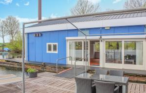 una casa azul sobre el agua con terraza de madera en Awesome Ship In Lith With Kitchen, en Lith