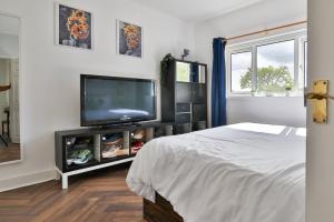 een slaapkamer met een flatscreen-tv en een bed bij Garden Station Dwelling in Rumney in Cardiff