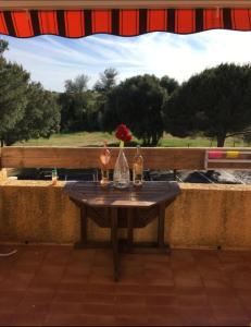 a table with two bottles and a vase with a flower on it at Studio rénové balcon ensoleillé et calme in La Londe-les-Maures