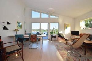 sala de estar con mesa y sillas en Underbart hus med fantastisk havsutsikt & nära till bad, en Svanesund
