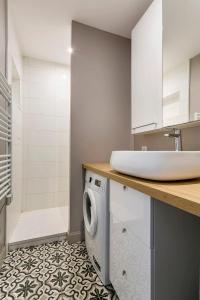 a bathroom with a sink and a washing machine at Hamac Suites - Le Bayard - 2 Bedrooms - Lyon 2 in Lyon