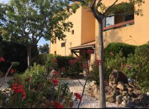 a garden in front of a building with flowers at Studio rénové balcon ensoleillé et calme in La Londe-les-Maures