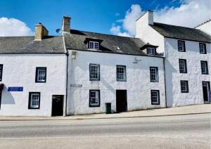 un vecchio edificio bianco sul lato di una strada di Charming and Cosy - Black's Land a Inveraray