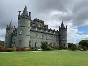 an old castle with turrets on a grass field at Charming and Cosy - Black's Land in Inveraray