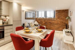 cocina y sala de estar con mesa blanca y sillas rojas en Charming retreat in Bradford, en Bradford