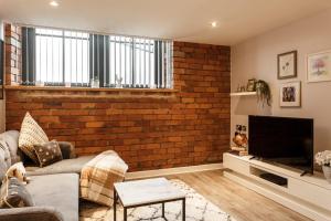 una sala de estar con una pared de ladrillo en Charming retreat in Bradford, en Bradford 13 fotos más