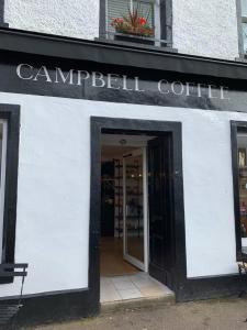 uma porta para uma loja com um sinal que lê café Campbell em Charming and Cosy - Black's Land em Inveraray