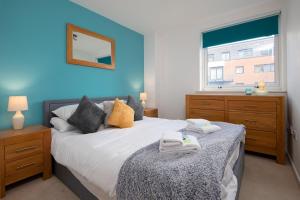 um quarto com uma cama grande e uma parede azul em The Ocean Village, Southampton em Southampton