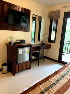 a room with a desk and a television in a room at Wind Beach Resort in Koh Tao