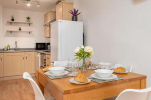 uma cozinha com uma mesa de madeira com comida em The Ocean Village, Southampton em Southampton