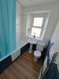 ein Bad mit einem Waschbecken, einem WC und einem Fenster in der Unterkunft Beautiful 2BR Home close to Beachfront in Weston-super-Mare