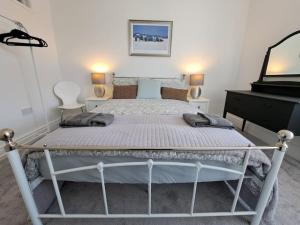 ein Bett in einem Schlafzimmer mit 2 Stühlen und einem Klavier in der Unterkunft Beautiful 2BR Home close to Beachfront in Weston-super-Mare