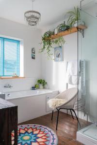 a bathroom with a tub and a sink and a chair at GuestReady - Magic Lantern House - Close to Beach in Brighton & Hove