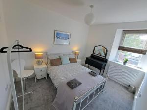 a bedroom with a bed and a desk at Beautiful 2BR Home close to Beachfront in Weston-super-Mare