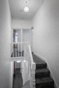 a white staircase in a room with a stair case at Delightful Family Home in Blackpool in Blackpool