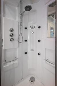 een witte badkamer met een douche en een toilet bij Delightful Family Home in Blackpool in Blackpool