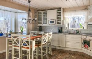 a kitchen with white cabinets and a table and chairs at Stunning Home In lvdalen With Sauna in Älvdalen