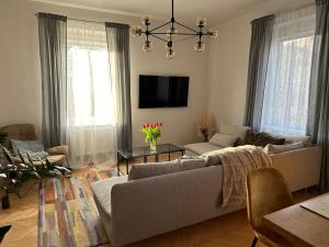 een woonkamer met een bank en een tv bij Blisko Plaży in Sopot