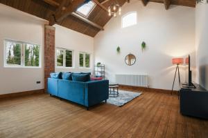 ein Wohnzimmer mit einem blauen Sofa und einem Fernseher in der Unterkunft Modern 5BR Victorian Home in Liverpool in Knowsley