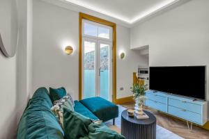 a living room with a blue couch and a flat screen tv at Hammersmith Residences by MySquare in London
