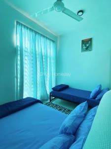 Habitación azul con 2 camas y ventana en Mesahill Studio 2 Fullbed by DKAY in Nilai, en Nilai