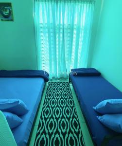 two beds in a room with a curtain at Mesahill Studio 2 Fullbed by DKAY in Nilai in Nilai