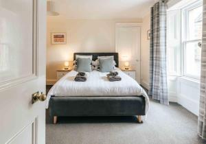 Un dormitorio con una cama con almohadas azules y una ventana en Kenmore House, Elie, en Elie