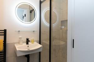 a bathroom with a sink and a shower at Elegant studio in New Malden in Malden