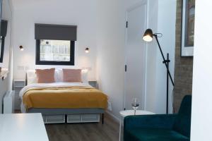 niewielka sypialnia z łóżkiem i krzesłem w obiekcie Elegant studio in New Malden w mieście Malden