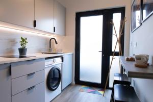 a laundry room with a washer and dryer in a kitchen at Elegant studio in New Malden in Malden
