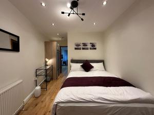 a bedroom with a large bed with a ceiling fan at Snug retreat in Reading in Earley