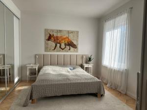 een slaapkamer met een bed en een schilderij van een vos bij Blisko Plaży in Sopot