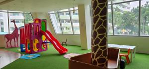 a room with a play area with a giraffe and a playground at JKrib Studio at The Residences Commonwealth in Manila