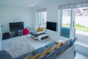 a living room with a couch and a flat screen tv at Luxury retreat in Shirley North in Elmers End