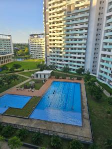 an overhead view of a swimming pool with tall buildings at JKrib Studio at The Residences Commonwealth in Manila