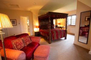 a bedroom with a four poster bed and a couch at Little Court in Charminster