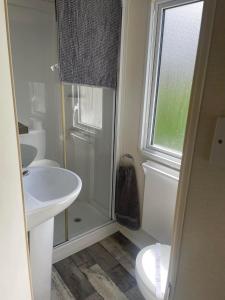 uma casa de banho com um lavatório, um WC e uma janela. em Littlesea Haven fleetview em Weymouth