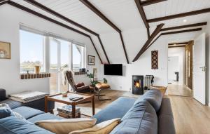 HavrvigにあるStunning Home In Hvide Sande With 3 Bedrooms And Wifiのリビングルーム(青いソファ、暖炉付)